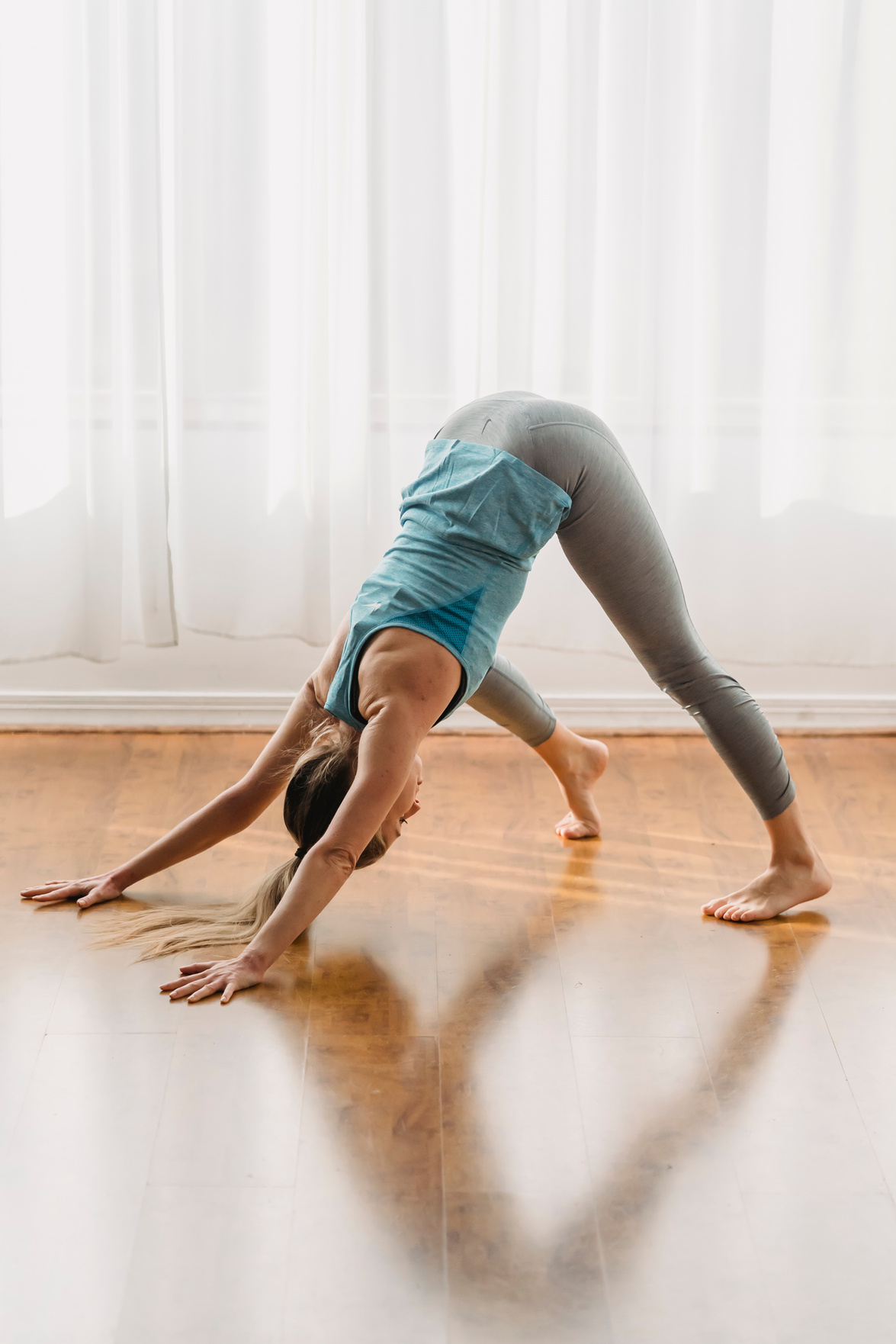 Woman doing yoga while performing downward facing dog pose