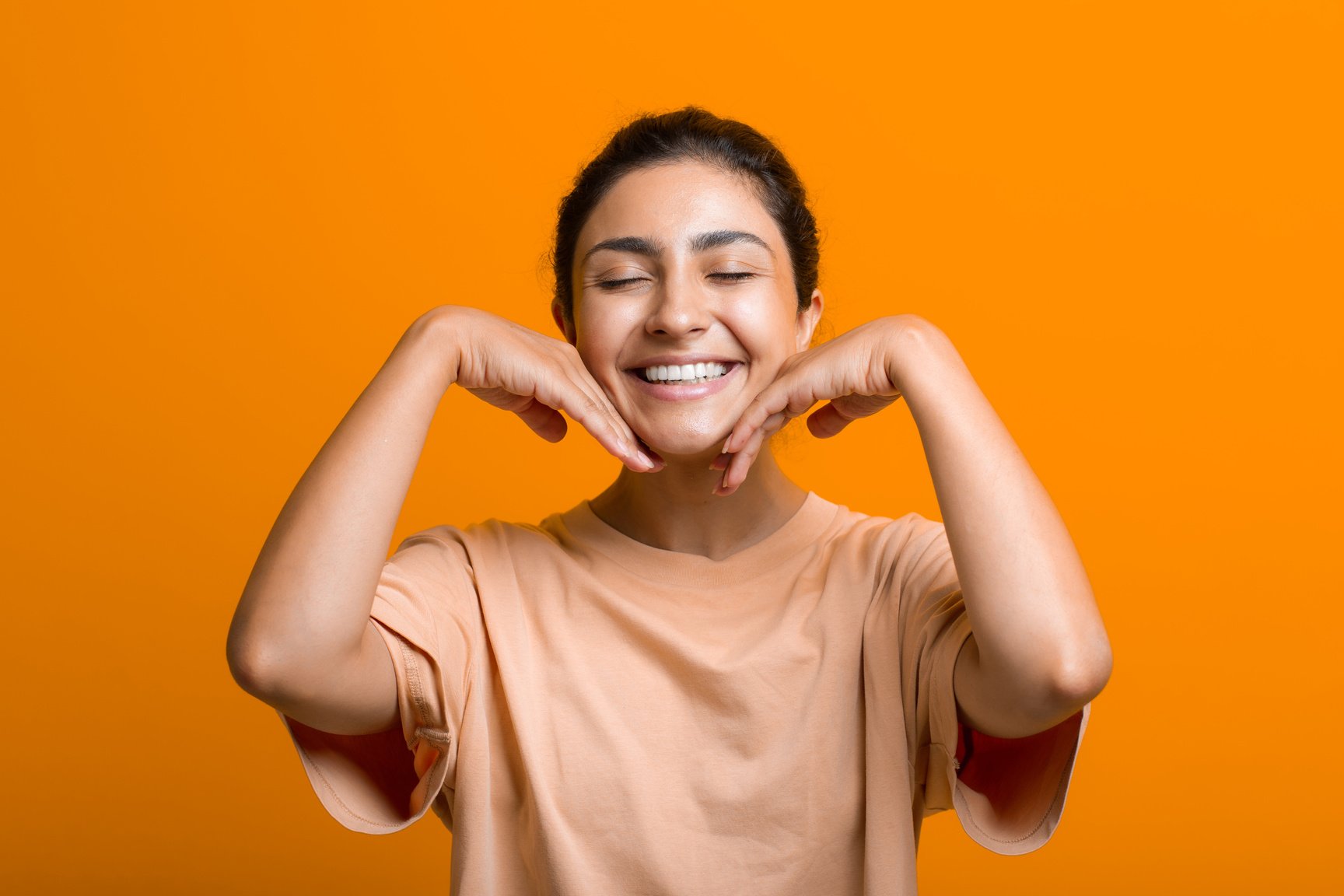 Close up Portrait of Young Indian American Woman Doing Facebuilding Yoga Face Gymnastics Yoga Self Facial Massage.