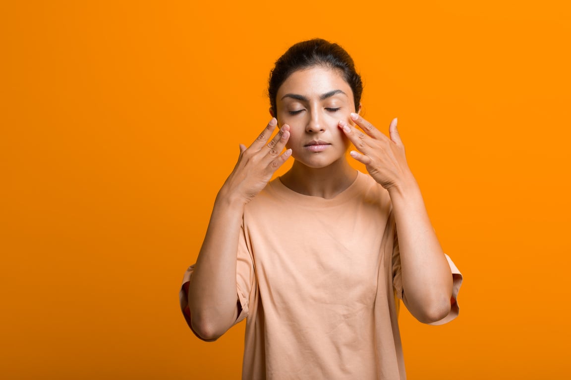 Close up Portrait of Young Indian American Woman Doing Facebuilding Yoga Face Gymnastics Yoga Self Massage.